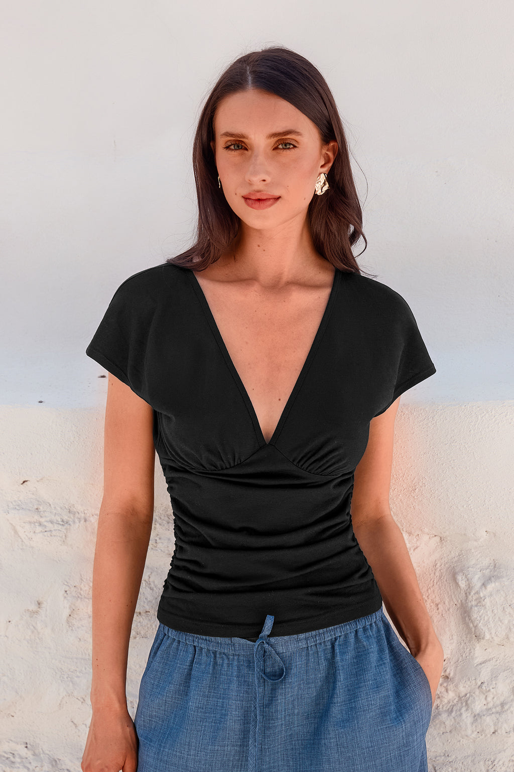 Schwarzes Top mit tiefem Ausschnitt und geraffter Taille