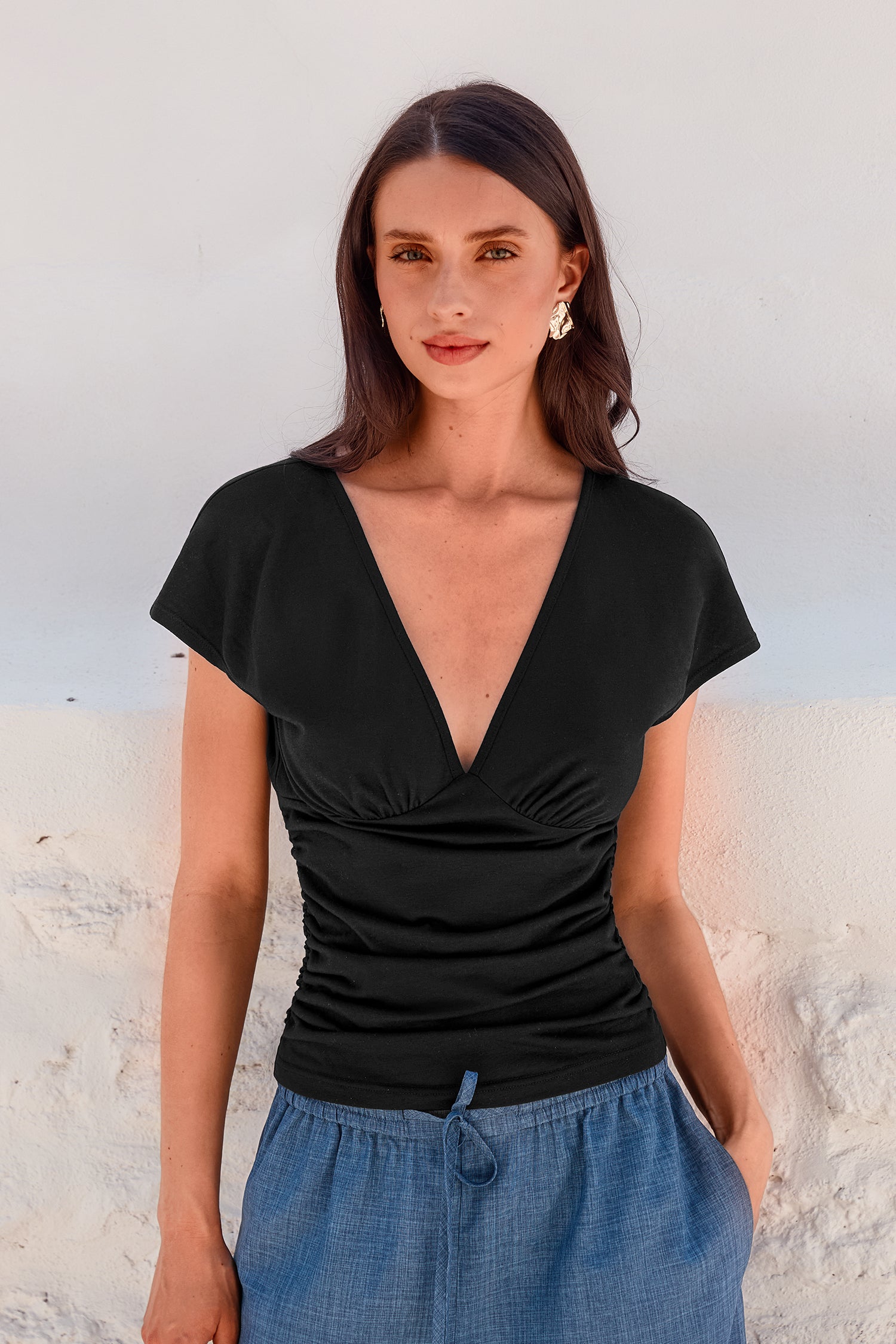 Schwarzes Top mit tiefem Ausschnitt und geraffter Taille